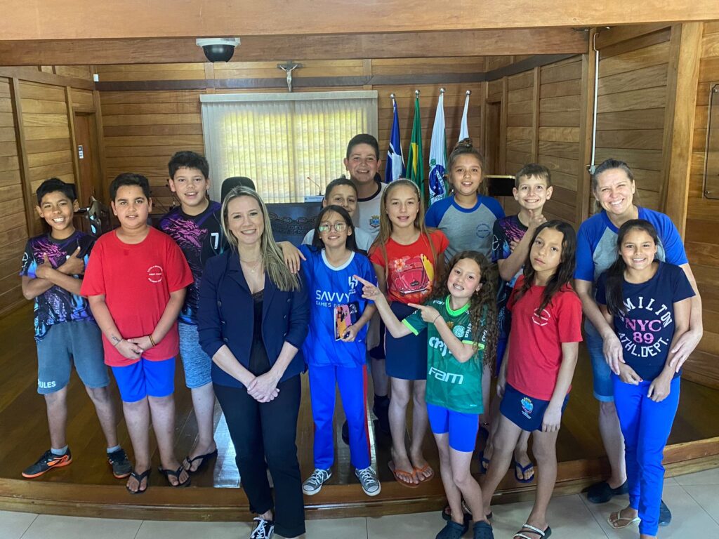 os alunos do 5º ano da Escola Hugo Guilherme Jaeger posam para a foto acompanhados da professora Eunice Marise Pinto e da Advogada da Câmara, Madeleine Sergea Souza, em frente ao plenário onde são realizadas as sessões do Legislativo.