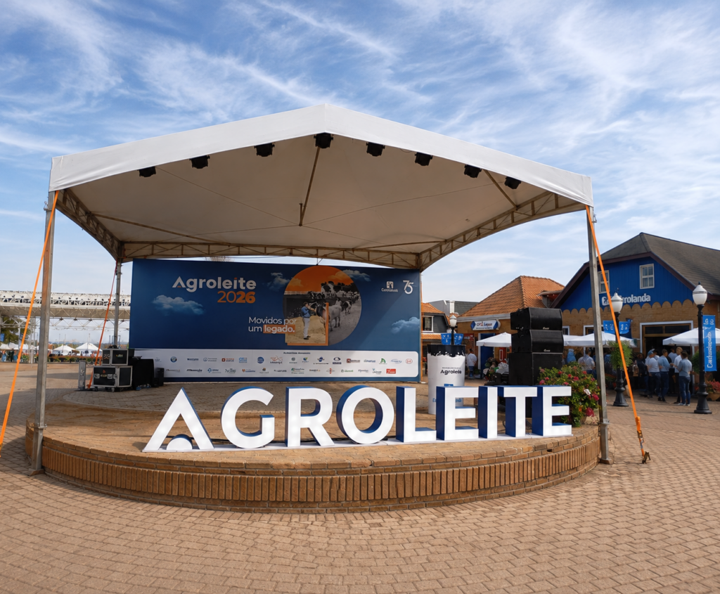Ao centro, aparece o letreiro: Agroleite. Aos fundos, uma tenda de exposições da feira